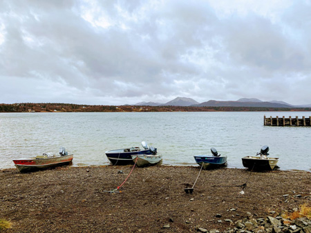 Small motor boats beached along the shore in Dillingham, Alaska